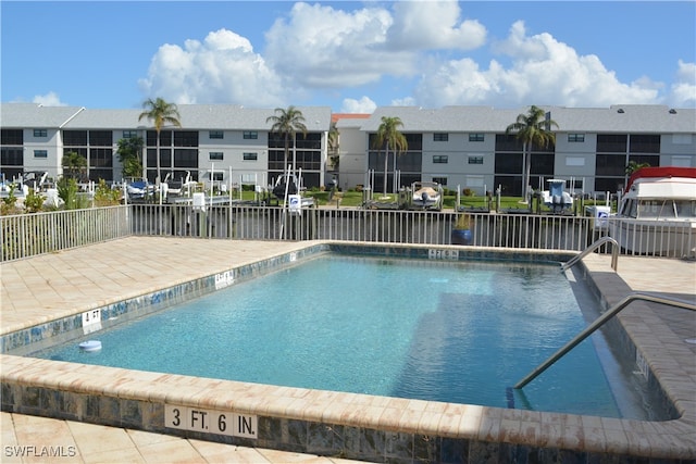 view of pool featuring a water view and a patio