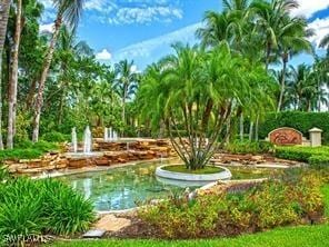 2843 Tiburon Blvd E Unit 7-102, Naples, FL 34109 - view of swimming pool featuring a small pond