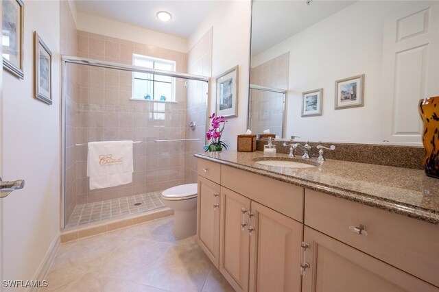 bathroom featuring vanity, tile patterned flooring, toilet, and an enclosed shower