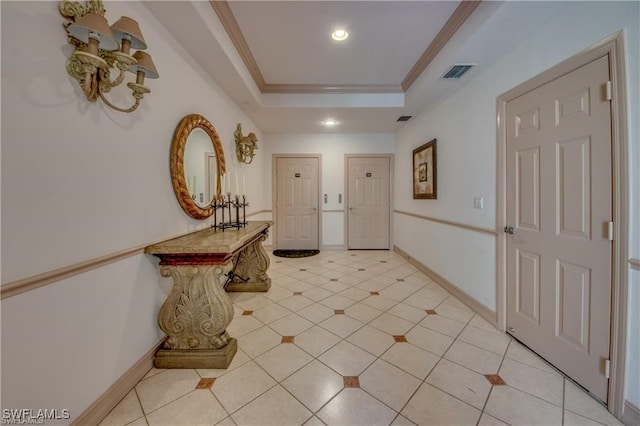 corridor featuring crown molding, a tray ceiling, and light tile patterned floors