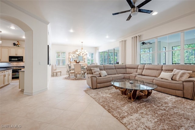 tiled living room featuring ceiling fan with notable chandelier