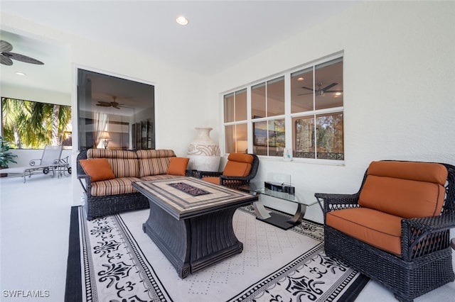 view of patio / terrace with ceiling fan and an outdoor living space with a fire pit