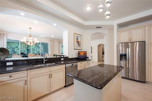 kitchen featuring sink, appliances with stainless steel finishes, pendant lighting, and an inviting chandelier