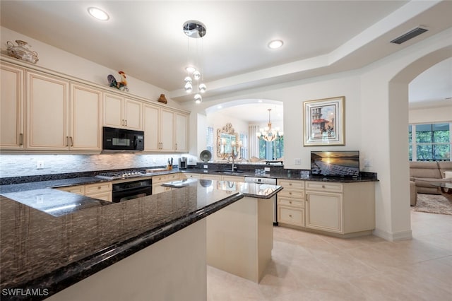 kitchen with decorative light fixtures, black appliances, sink, and dark stone counters