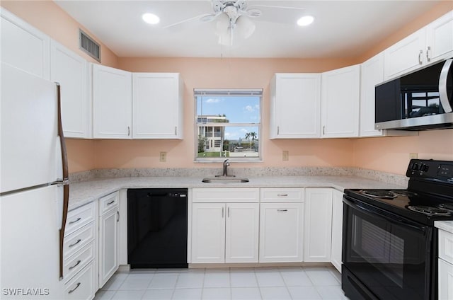 kitchen with black appliances, light stone counters, white cabinets, and sink