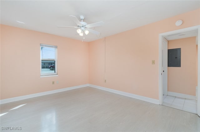 empty room featuring ceiling fan, light wood-type flooring, and electric panel