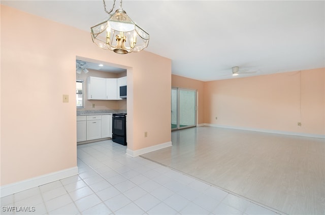 interior space featuring ceiling fan with notable chandelier