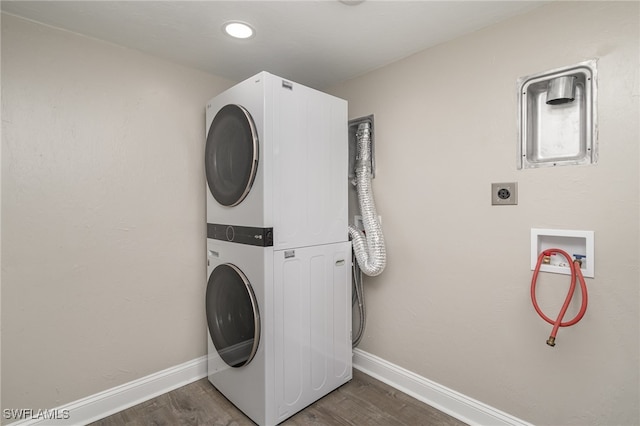 laundry area featuring stacked washer and dryer and dark hardwood / wood-style floors