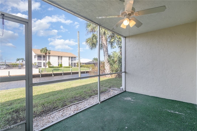 unfurnished sunroom featuring ceiling fan