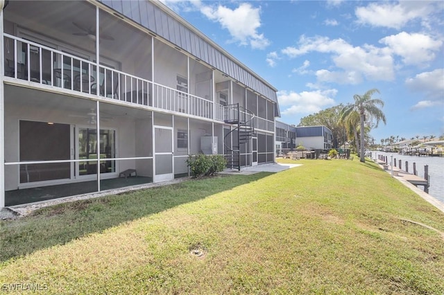 exterior space with ceiling fan and a water view