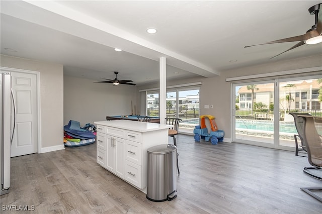 kitchen featuring light hardwood / wood-style flooring, white cabinetry, a wealth of natural light, and ceiling fan