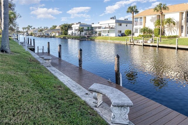 dock area featuring a water view and a yard