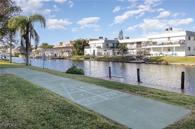 surrounding community featuring a lawn and a water view