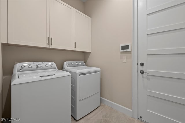 laundry area featuring cabinets, washer and clothes dryer, and light tile patterned floors