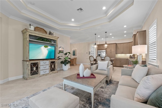 living room featuring ornamental molding, a tray ceiling, and light tile patterned floors