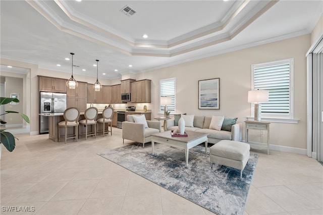 living room featuring a tray ceiling, a healthy amount of sunlight, ornamental molding, and light tile patterned floors