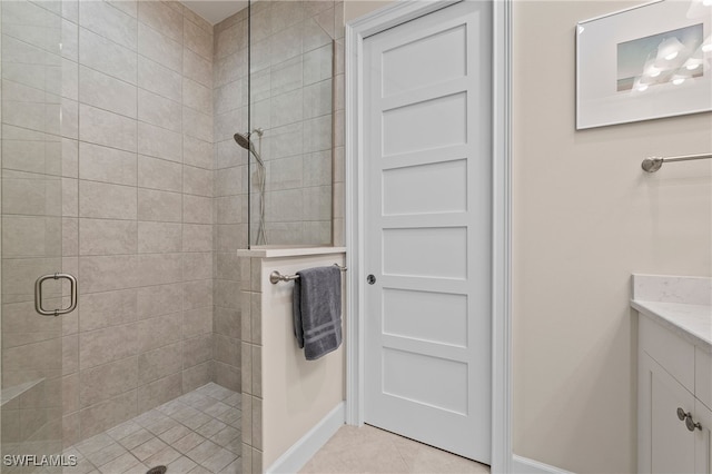 bathroom with a shower with door, tile patterned flooring, and vanity