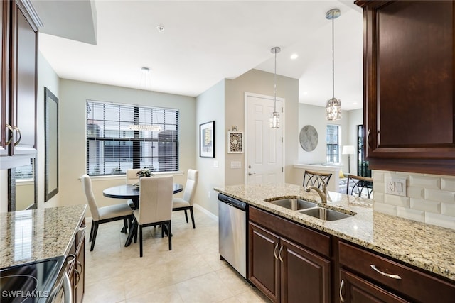 kitchen featuring light stone countertops, sink, stainless steel appliances, pendant lighting, and dark brown cabinets