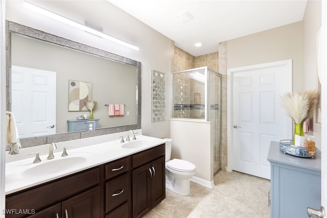 bathroom featuring tile patterned flooring, vanity, a shower with door, and toilet