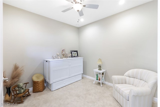 living area with ceiling fan and light colored carpet