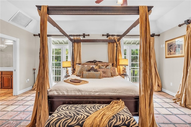 tiled bedroom with connected bathroom and multiple windows