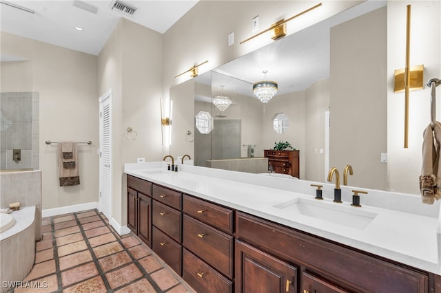 bathroom with vanity, a chandelier, and a tile shower