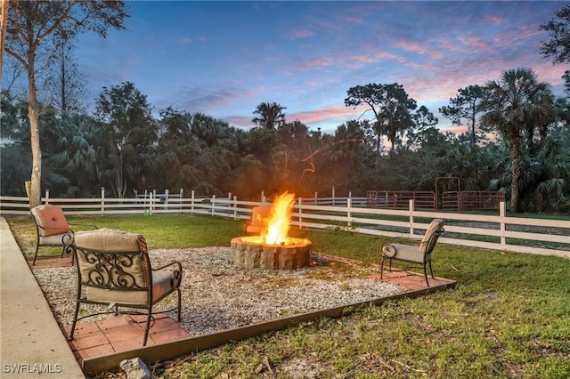685 11th St NW, Naples, FL 34120 - yard at dusk with an outdoor fire pit and view of scattered trees