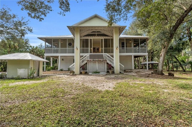 685 11th St NW, Naples, FL 34120 - rear view of house with a sunroom, stairs, and a lawn