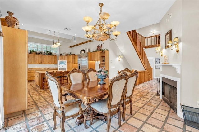 685 11th St NW, Naples, FL 34120 - dining space featuring a chandelier, stairway, light stone finish floors, and a fireplace