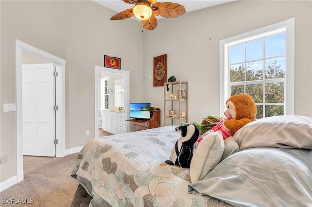 bedroom featuring connected bathroom, light carpet, and ceiling fan