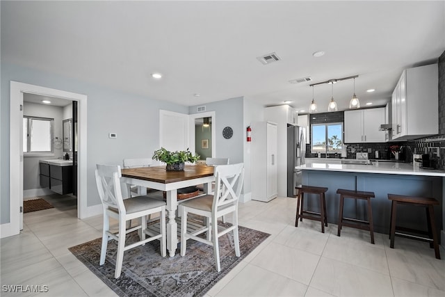 dining area with sink and light tile patterned flooring