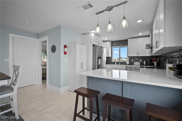 kitchen with white cabinetry, appliances with stainless steel finishes, kitchen peninsula, and a kitchen breakfast bar