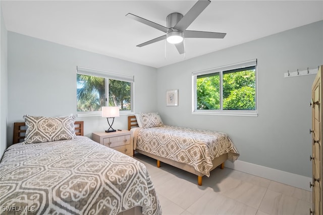 tiled bedroom featuring multiple windows and ceiling fan