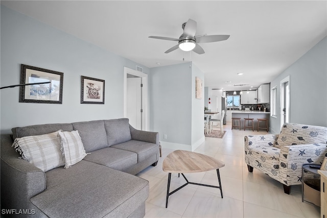 tiled living room featuring ceiling fan