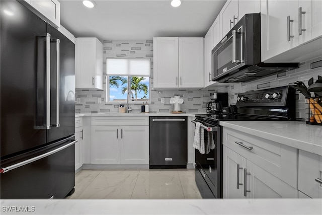 kitchen featuring white cabinets, black appliances, and backsplash