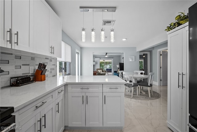 kitchen with white cabinets, kitchen peninsula, pendant lighting, and ceiling fan