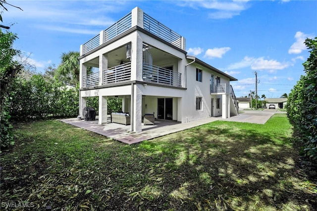 back of property featuring a yard, a patio, a balcony, and outdoor lounge area