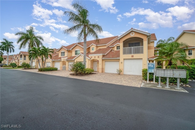 view of front of property featuring a balcony and a garage