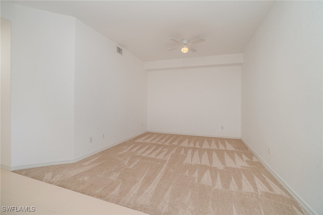 empty room featuring ceiling fan and light colored carpet