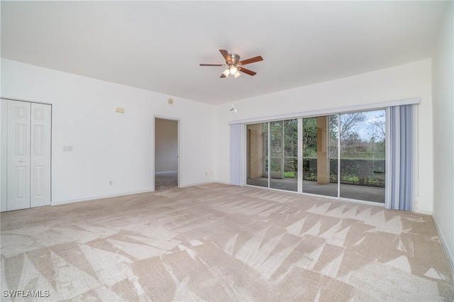 spare room with light colored carpet and ceiling fan