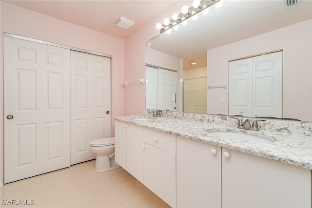 bathroom featuring vanity, toilet, walk in shower, and tile patterned flooring