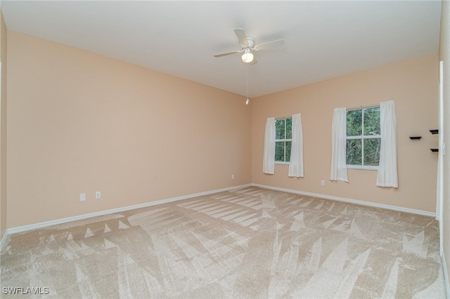 empty room featuring ceiling fan and light colored carpet