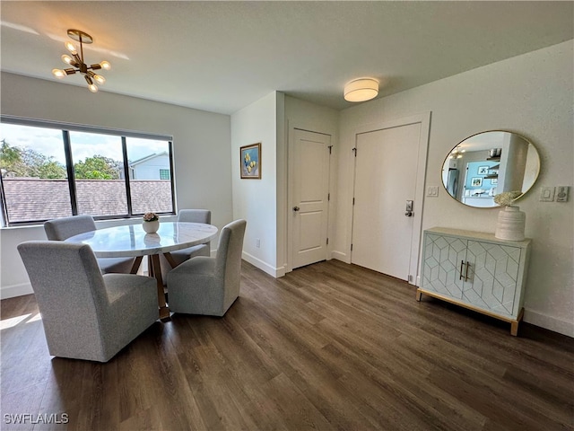 dining space with dark hardwood / wood-style flooring and an inviting chandelier