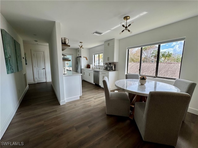 dining space featuring dark hardwood / wood-style floors and an inviting chandelier