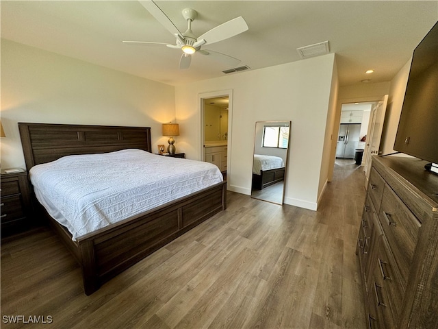 bedroom featuring hardwood / wood-style floors, ceiling fan, and connected bathroom