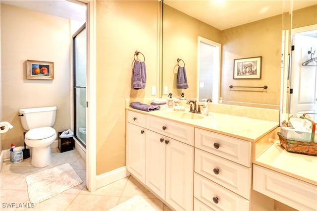 bathroom with tile patterned flooring, vanity, toilet, and walk in shower