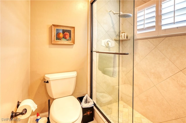 bathroom featuring an enclosed shower and toilet