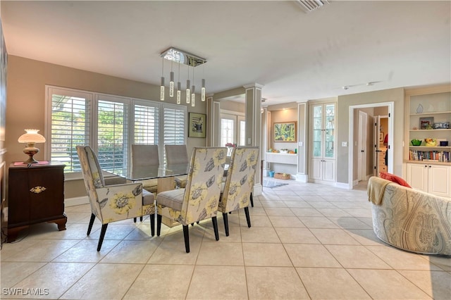 dining room with a notable chandelier, light tile patterned flooring, and built in shelves