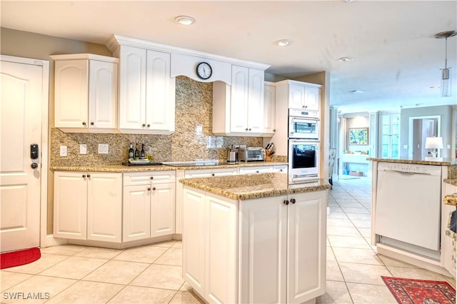 kitchen with white appliances, white cabinets, decorative backsplash, light tile patterned floors, and a kitchen island