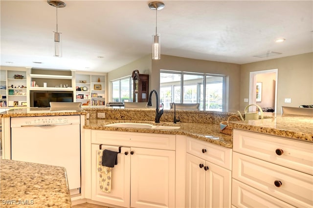 kitchen with white cabinetry, dishwasher, sink, hanging light fixtures, and light stone counters